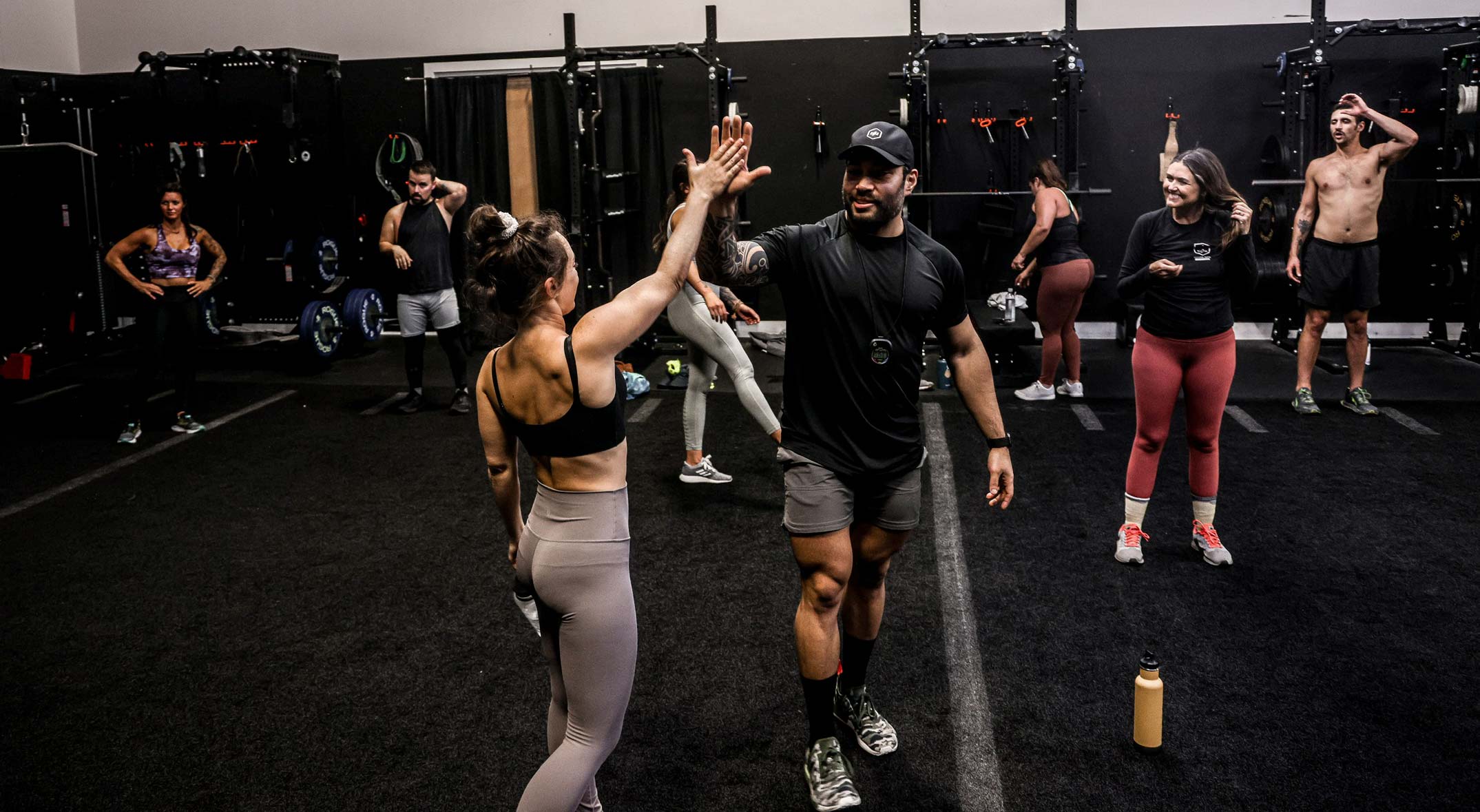 Coach doing high five with memebers in the gym